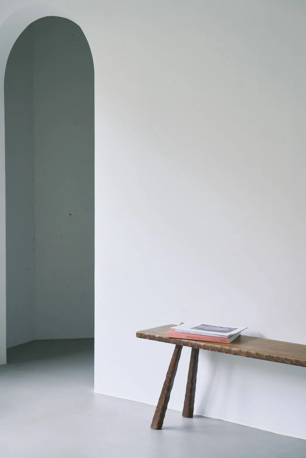 アーチ形の入口と木製ベンチがあるWHITE ROOM